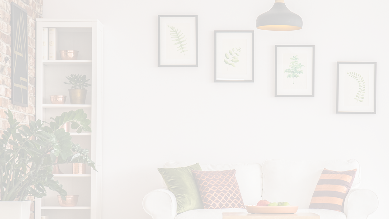 Whitened image of a living room setup with wall pictures, a couch, anda bookshelf