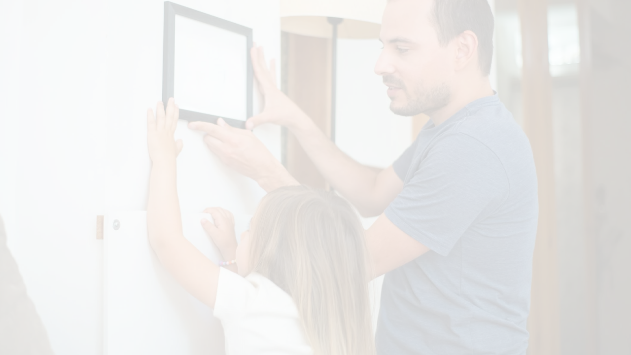 A woman hanging a picture on a gallery wall