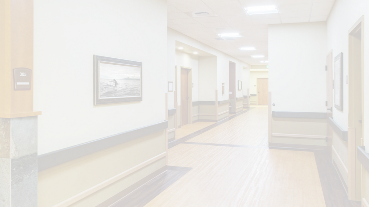 whitened image of a hospital corridor. on the walls are framed pictures