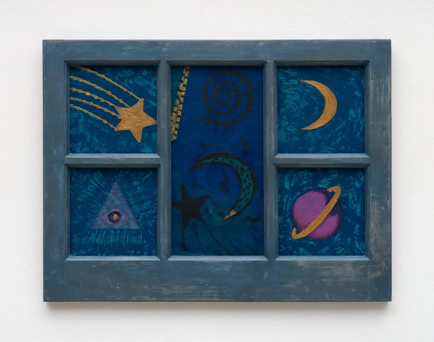 An upcycle window frame used as a canvas and painted over in blue.